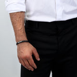 Ανδρικό βραχιόλι Maserati JM222AVE02 από ανακυκλομένο δέρμα σε μαύρο χρώμα με ασημί ατσάλινο στοιχείο ασημί τρίαινα και μαύρο μπρασελέ-φορεμένο.