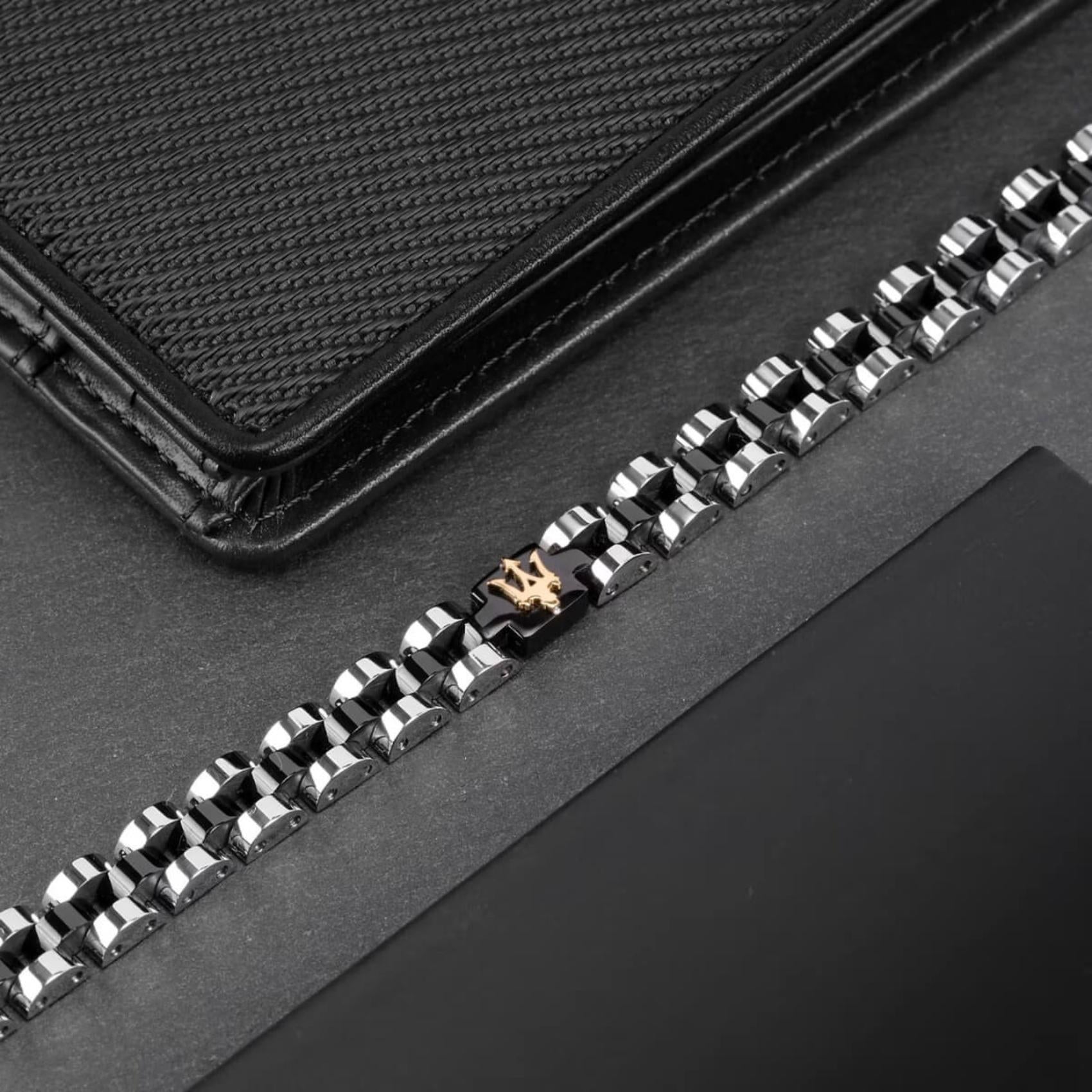 Ανδρικό βραχιόλι Maserati JM320AST08 από ανοξείδωτο ατσάλι, με ασημί-μαύρο μπρασελέ και μαύρο στοιχείο με χρυσή τρίαινα.