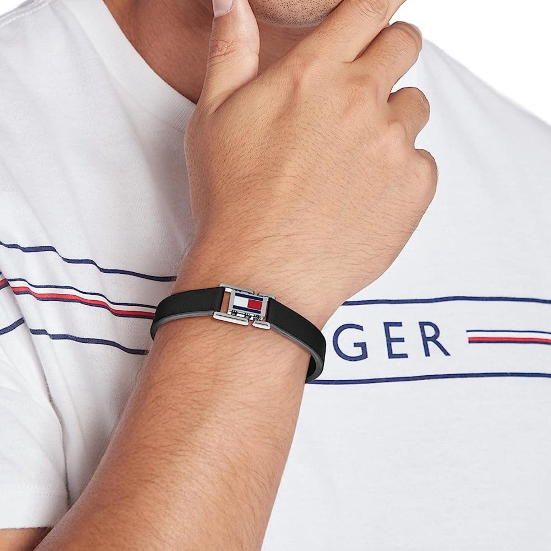 Ανδρικό δερμάτινο βραχιόλι Tommy Hilfiger σε μαύρο χρώμα φορεμένο σε ανδρικό χέρι.