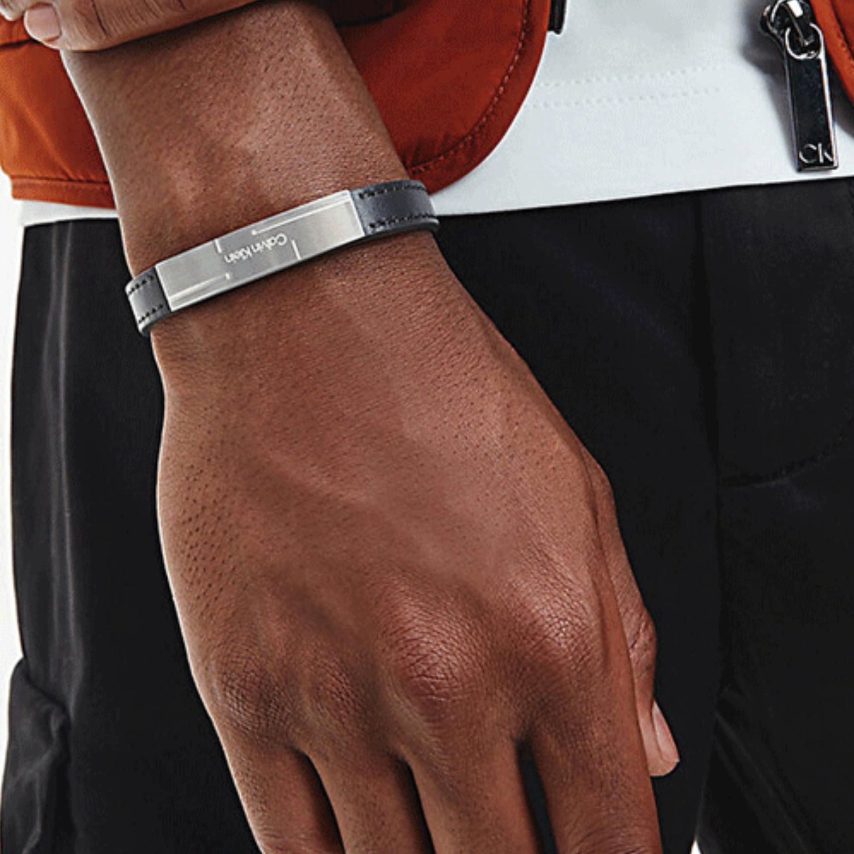 Ανδρικό βραχιόλι Calvin Klein 35000056 από μαύρο δέρμα με ασημένια αγκράφα.