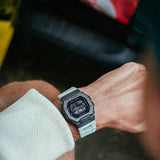 Ρολόι με λειτουργίες προπόνησης Casio G-Lide G-Shock GBX-100TT-8ER με γκρι καουτσούκ λουράκι και μαύρο καντράν διαμέτρου 46mm σε τετράγωνο σχημα.