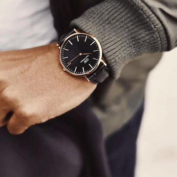 Ρολόι Daniel Wellington Classic Reading DW00100129 με μαύρο δερμάτινο λουράκι, μαύρο καντραν, μηχανισμό μπαταρίας και στρογγυλό σχήμα με διάμετρο 36mm αδιάβροχο στις 3ΑΤΜ-30Μ.