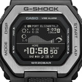 Ρολόι με λειτουργίες προπόνησης Casio G-Lide G-Shock GBX-100TT-8ER με γκρι καουτσούκ λουράκι και μαύρο καντράν διαμέτρου 46mm σε τετράγωνο σχημα.