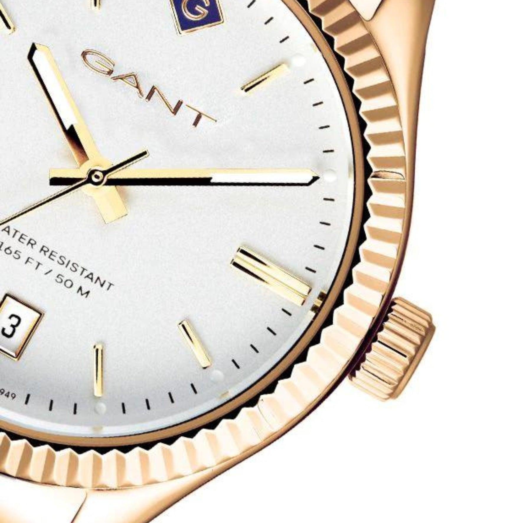Γυναικείο ρολόι Gant Sussex G136008 με χρυσό ατσάλινο μπρασελέ, άσπρο καντραν, τζαμάκι από ορυκτο κρύσταλλο μηχανισμό μπαταρίας με ένδειξη ημερομηνίας και στρογγυλό στεφάνι διαμέτρου 34mm, αδιάβροχο στις 5ΑΤΜ-50Μ.