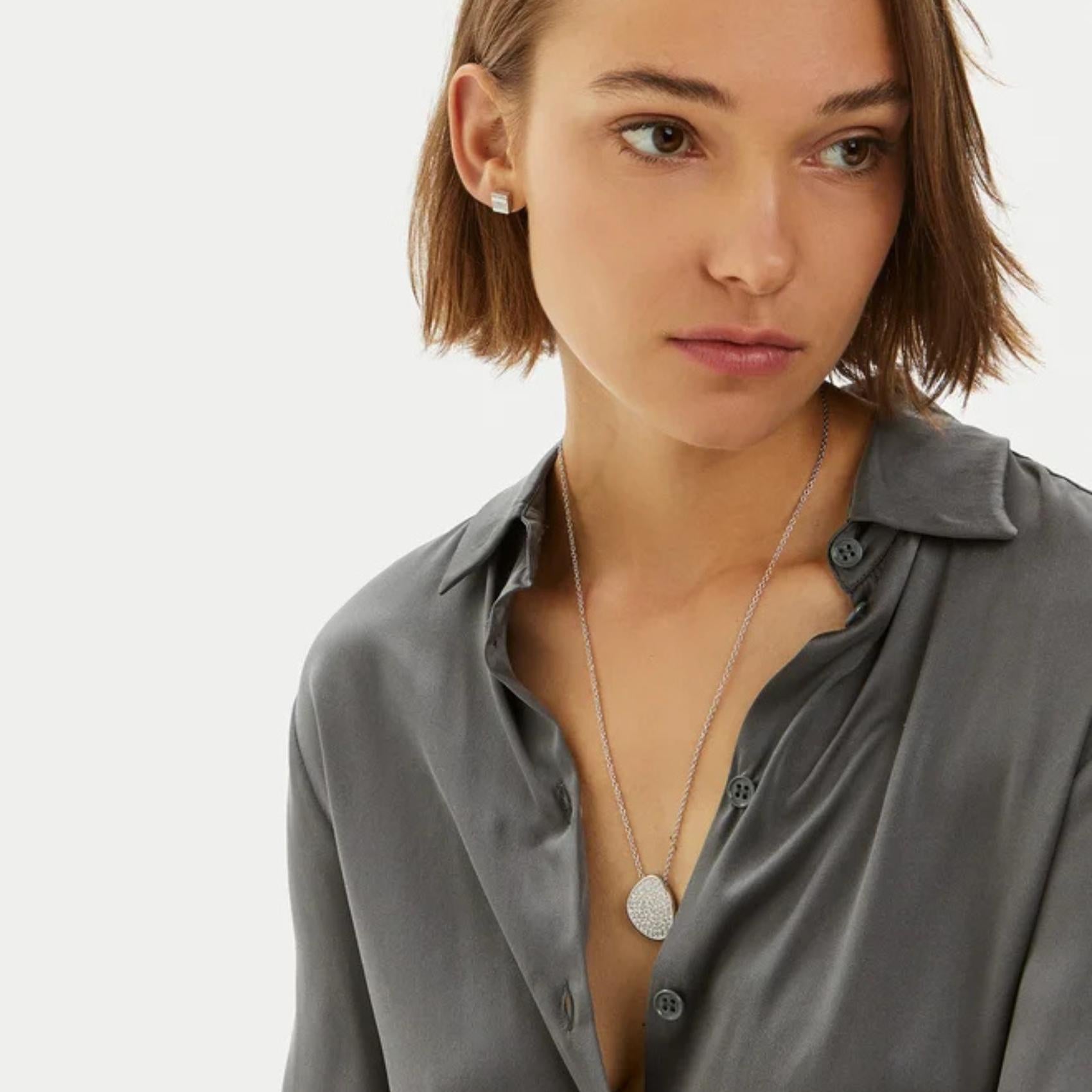 Γυναικείο κολιέ Calvin Klein 35000222 ατσάλινο σε ασημί χρώμα διακοσμημένο με λευκά ζιργκόν, φορεμένο.