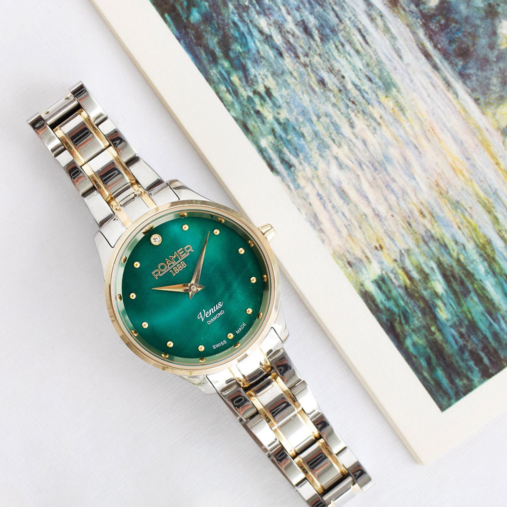 Ρολόι Roamer Venus Diamonds 601857-47-59-20 με δίχρωμο ασημί-χρυσό ατσάλινο μπρασελέ, πράσινο φίλντισι καντράν με διαμάντια, μηχανισμό μπαταρίας quartz, τζαμάκι από ζαφείρι και στεφάνι διαμέτρου 30mm.