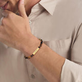 Ανδρικό βραχιόλι Calvin Klein 35000576 με καφέ χάντρες και επίχρυσα στοιχεία.