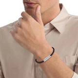 Δερμάτινο βραχιόλι Calvin Klein 35000582 σε μαύρο χρώμα με διαγώνια πλέξη και ασημί αγκράφα.