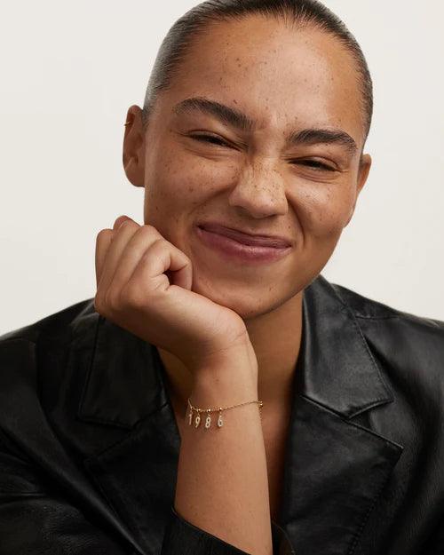 PD Paola Charm με αριθμούς, επιχρυσωμένο ασήμι με ζιργκόν, σε μοντέλο.