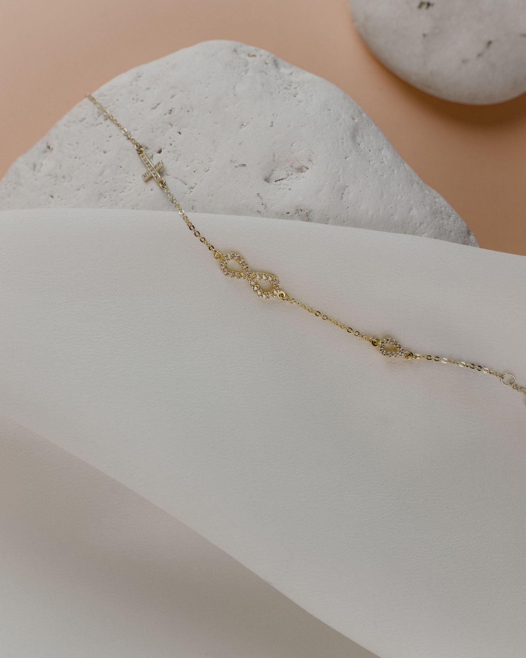 Βραχιόλι χρυσό με άπειρο και σταυρό BT5102.009
