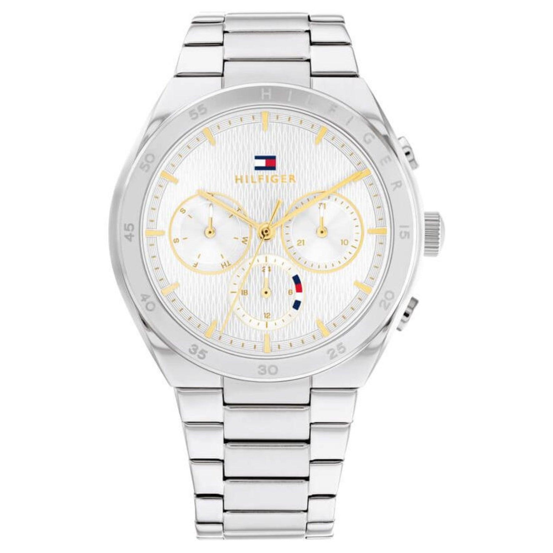 Γυναικείο ρολόι Tommy Hilfiger Carrie 1782573, με μπρασελέ σε ασημί χρώμα από ανοξείδωτο ατσάλι και λευκό καντράν με χρονογράφους και δείκτες σε χρυσό χρώμα.