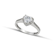 μονόπετρο δαχτυλίδι ροζέτα με κεντρικό διαμάντι σε σχήμα καρδιάς και πλαίνές πέτρες από μικρότερα διαμάντια, κατασκευασμένο από λευκόχρυσο φορεμένο σε γυναικείο χέρι..