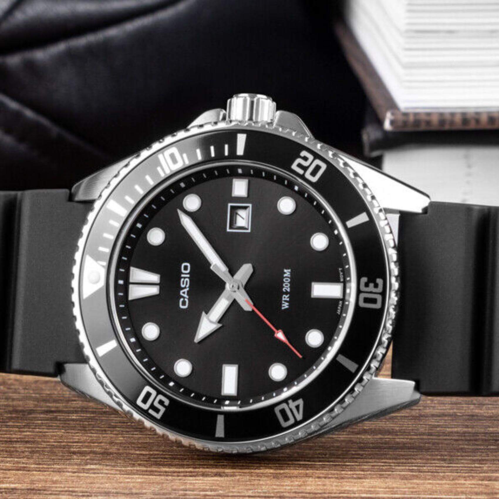 Καταδυτικό ρολόι CASIO MDV-107-1A1VEF με μαύρο λουράκι από καουτσούκ, μαύρο καντράν με φωσφορίζον δείκτες, περιστρεφόμενη στεφάνη σε μαύρο χρώμα και ένδειξη ημερομηνίας.