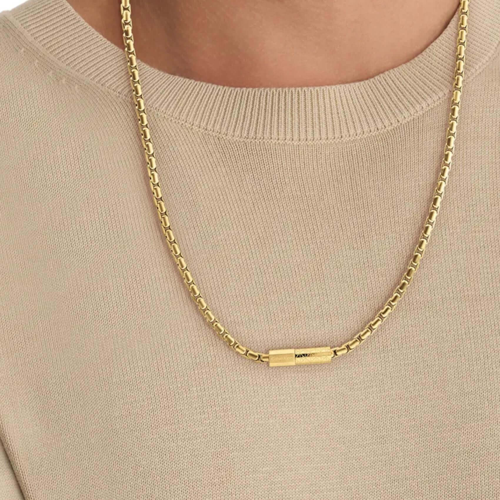 Ανδρική αλυσίδα Calvin Klein 35100093 φορεμένη σε χρυσό χρώμα με ενσωματωμένο χρυσό στοιχείο.