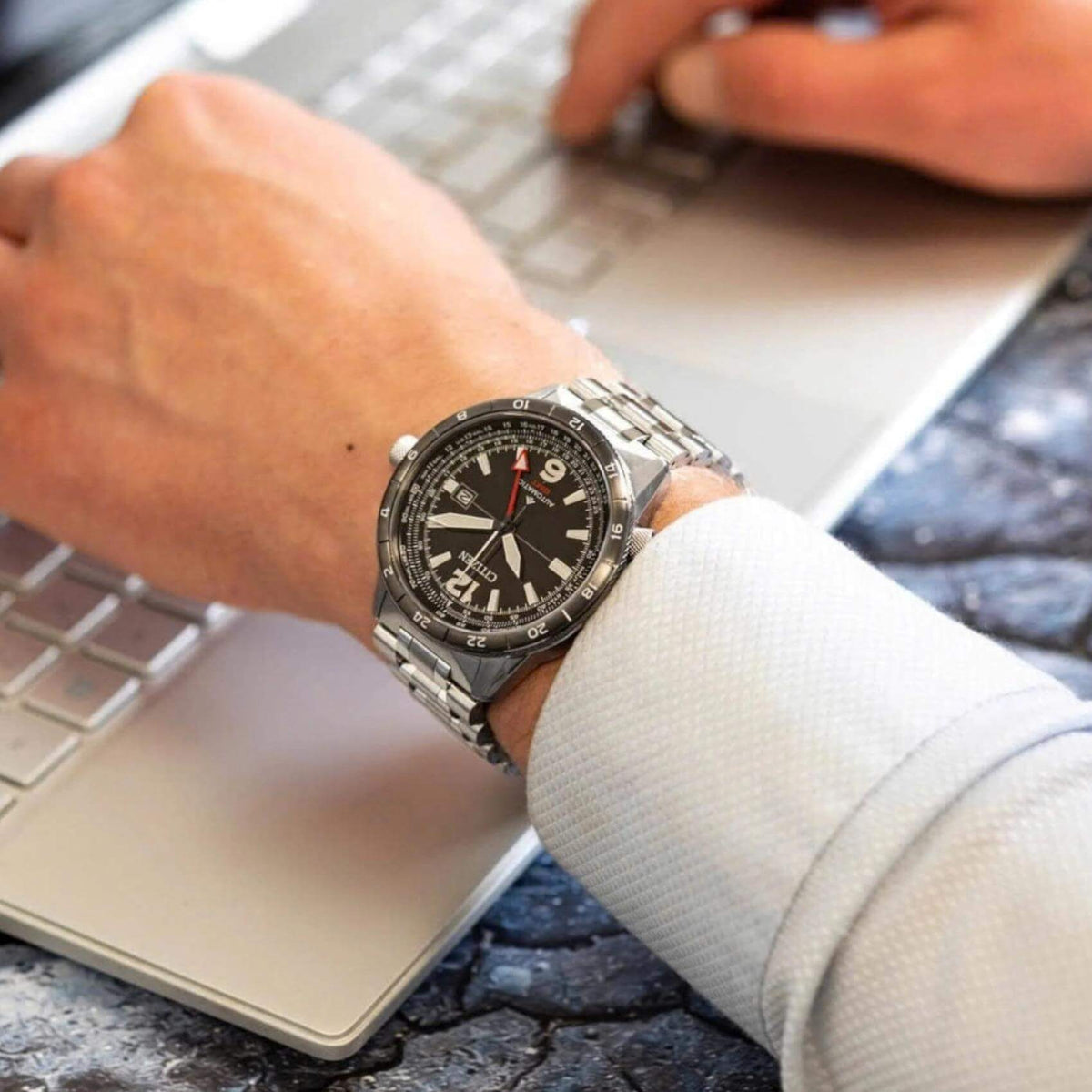 Ανδρικό ρολόι Citizen Promaster Mechanical GMT NB6046-59E φορεμένο με ασημί ατσάλινο μπρασελέ και μαύρο καντράν.