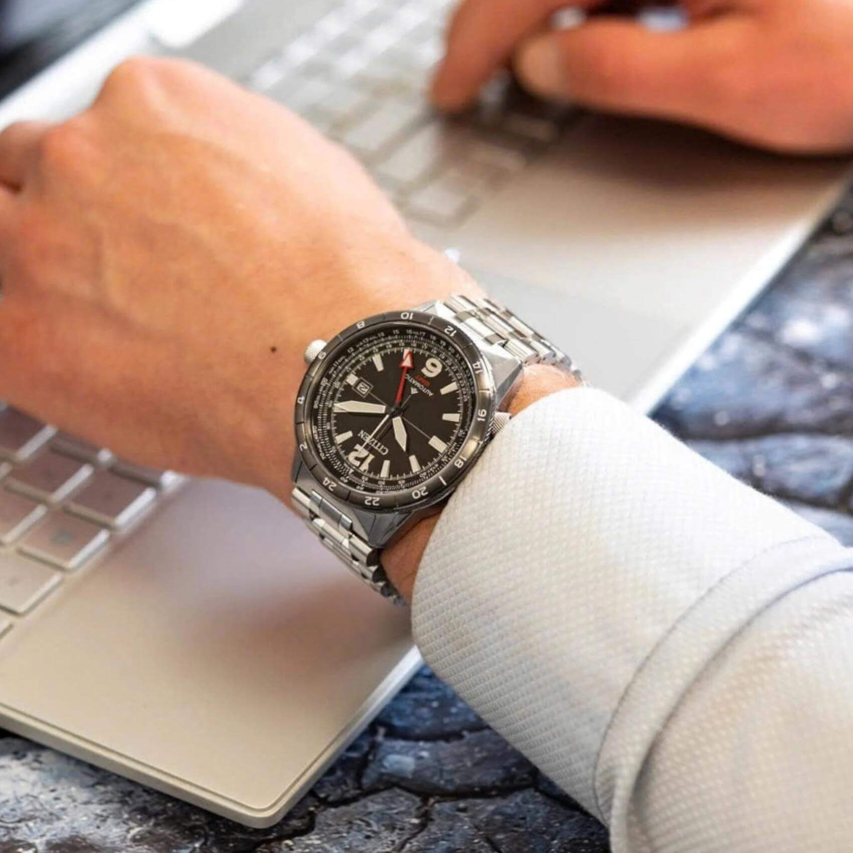 Ανδρικό ρολόι Citizen Promaster Mechanical GMT NB6046-59E φορεμένο με ασημί ατσάλινο μπρασελέ και μαύρο καντράν.