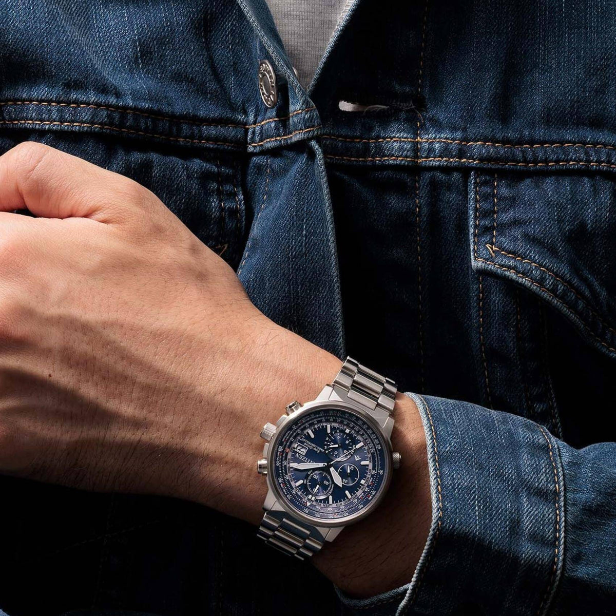 Ανδρικό ρολόι Citizen Promaster Sky AT8300-58L φορεμένο με ασημί μπρασελέ και μπλε καντράν.