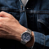 Ανδρικό ρολόι Citizen Promaster Sky AT8300-58L φορεμένο με ασημί μπρασελέ και μπλε καντράν.