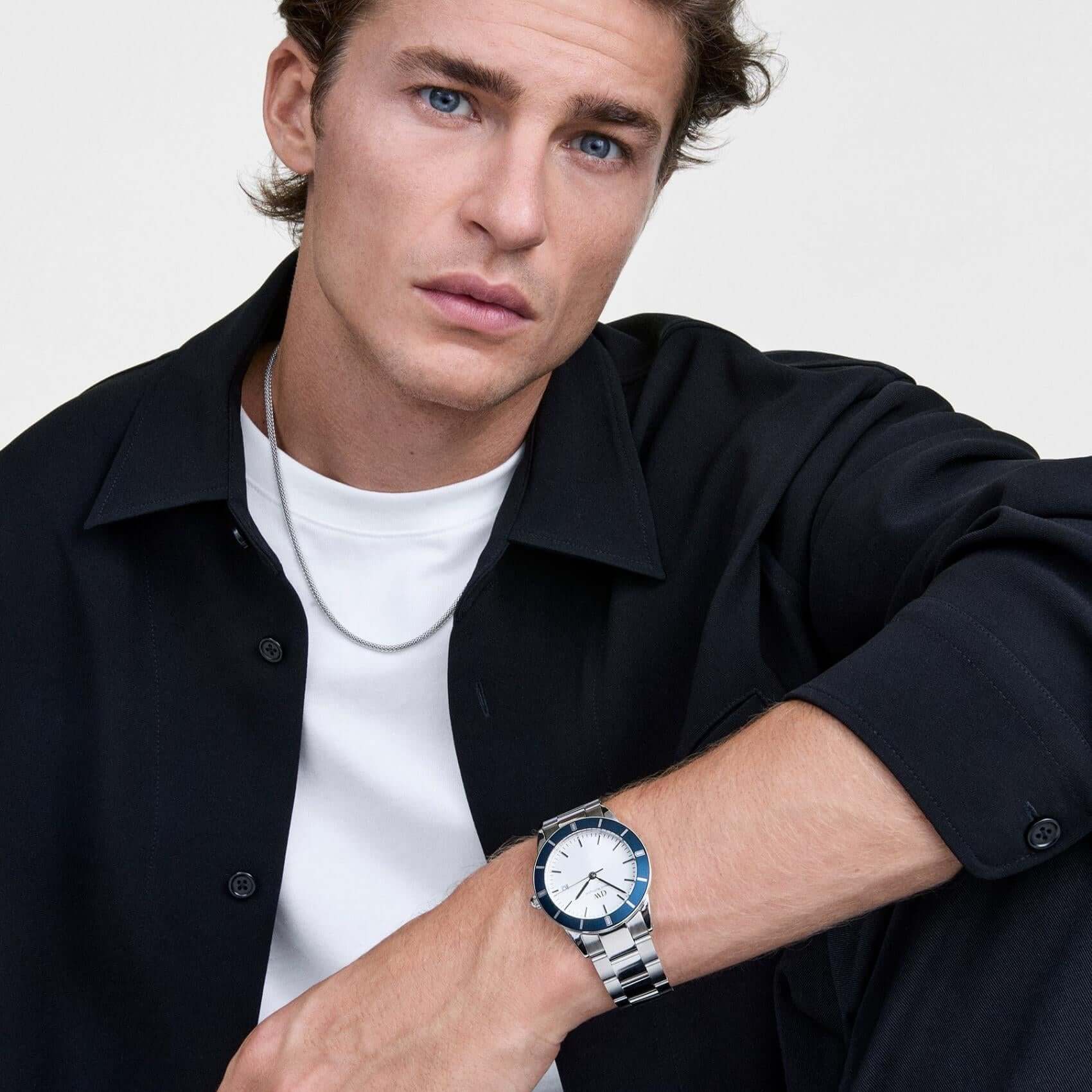 Ανδρικό ρολόι Daniel Wellington Iconic Paradigma DW00100818 φορεμένο με ασημί ατσάλινο μπρασελέ, ασημί καντράν και μπλε λεπτομέρειες.