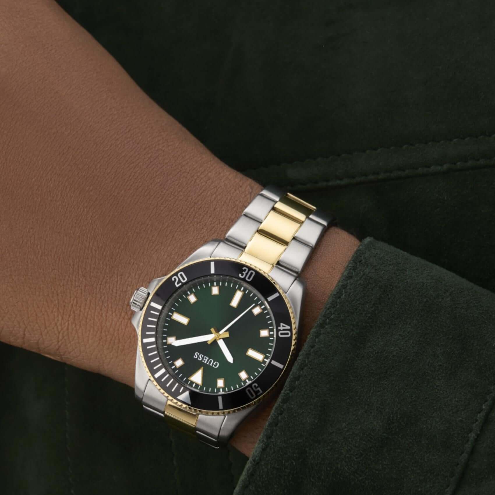 Ανδρικό ρολόι Guess Cliff GW0968G4 φορεμένο με δίχρωμο ατσάλινο μπρασελέ σε ασημί και χρυσό χρώμα, πράσινο καντράν και χρυσές λεπτομέρειες.
