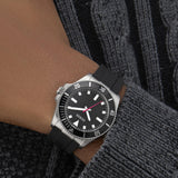 Ανδρικό ρολόι Guess Cliff GW0969G1 φορεμένο με μαύρο λουράκι από καουτσούκ, μαύρο καντράν και ασημί λεπτομέρειες.