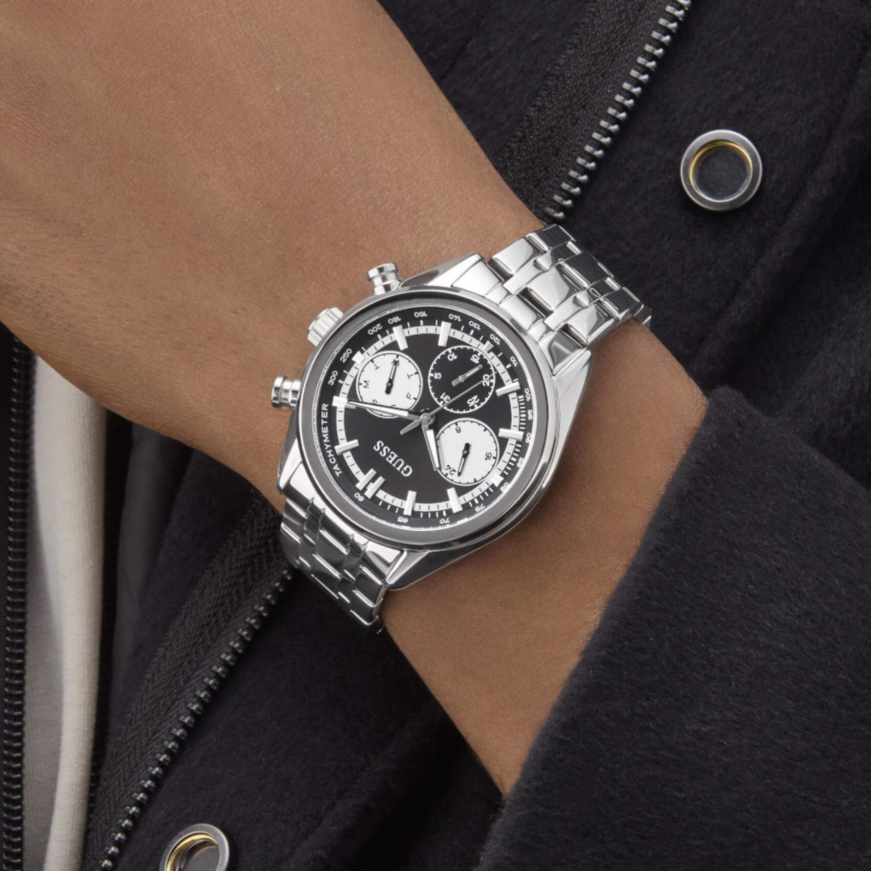 Ανδρικό ρολόι Guess Dawson GW0971G1 φορεμένο με ασημί ατσάλινο μπρασελέ, μαύρο καντράν και ασημί λεπτομέρειες.