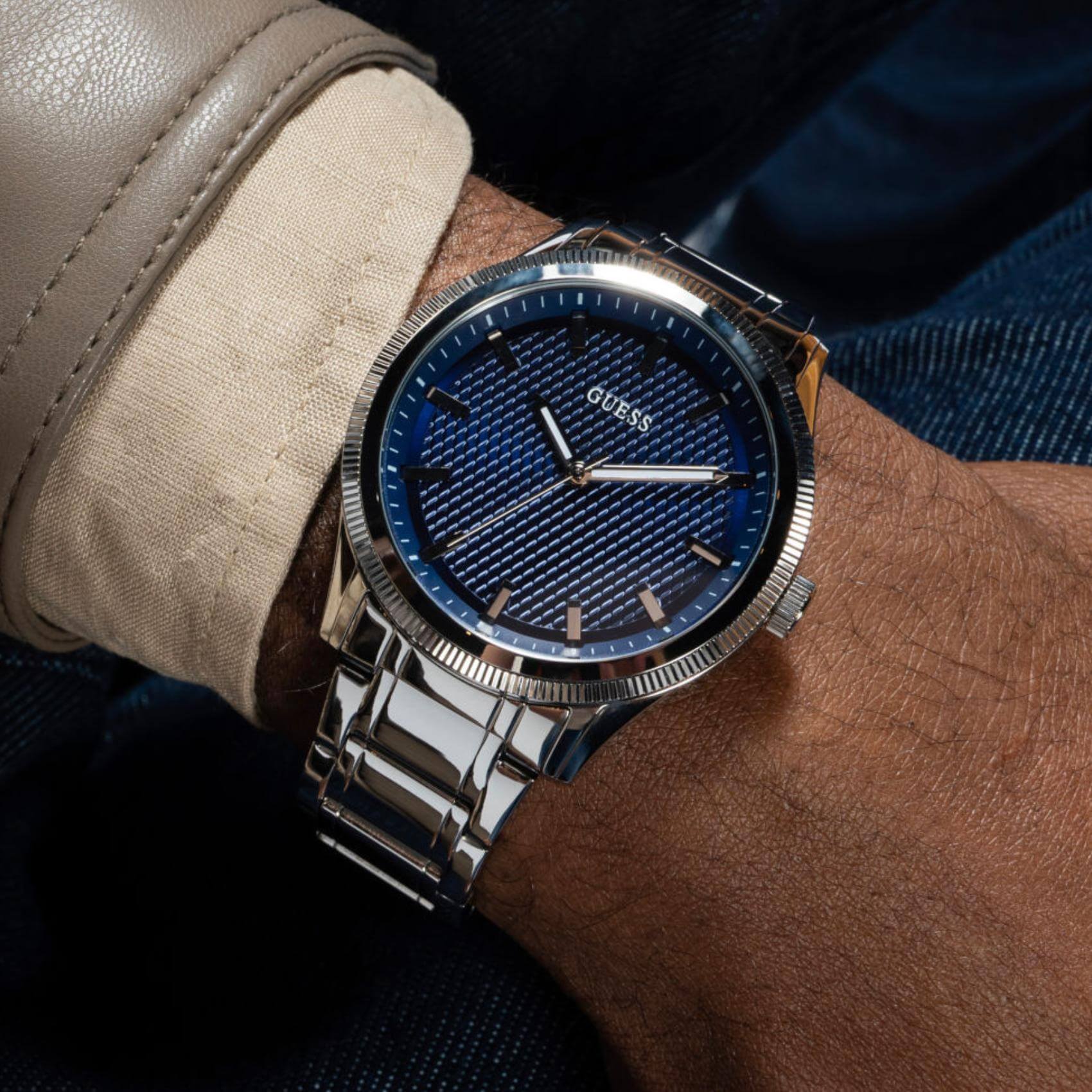Ανδρικό ρολόι Guess Dex GW0626G1 φορεμένο με ασημί ατσάλινο μπρασελέ, μπλε καντράν και ασημί λεπτομέρειες.