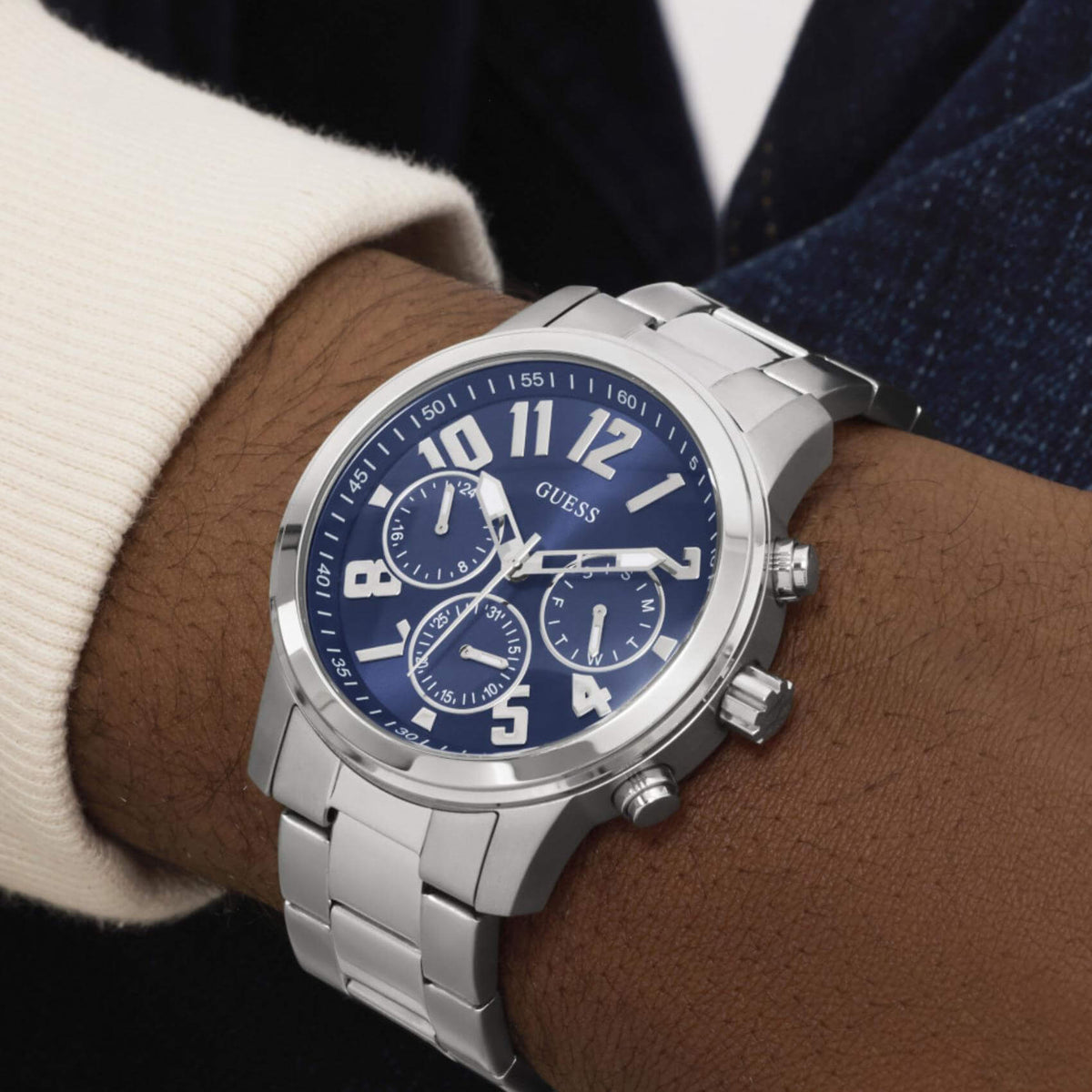 Ανδρικό ρολόι Guess Parker GW1006G1 φορεμένο με ασημί ατσάλινο μπρασελέ, μπλε καντράν και ασημί λεπτομέρειες.