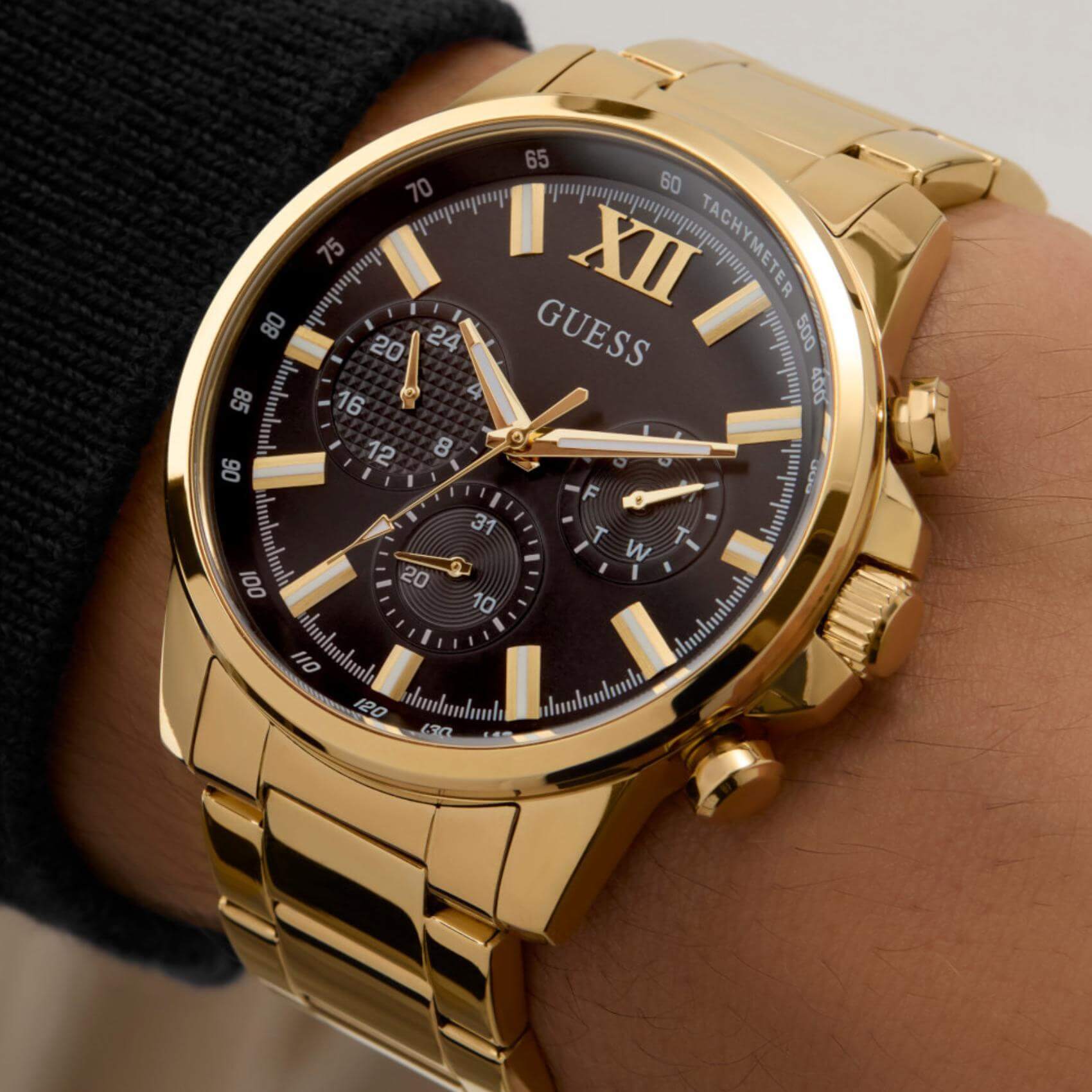 Ανδρικό ρολόι Guess Walker GW0900G3 φορεμένο με χρυσό ατσάλινο μπρασελέ, μαύρο καντράν και χρυσές λεπτομέρειες.