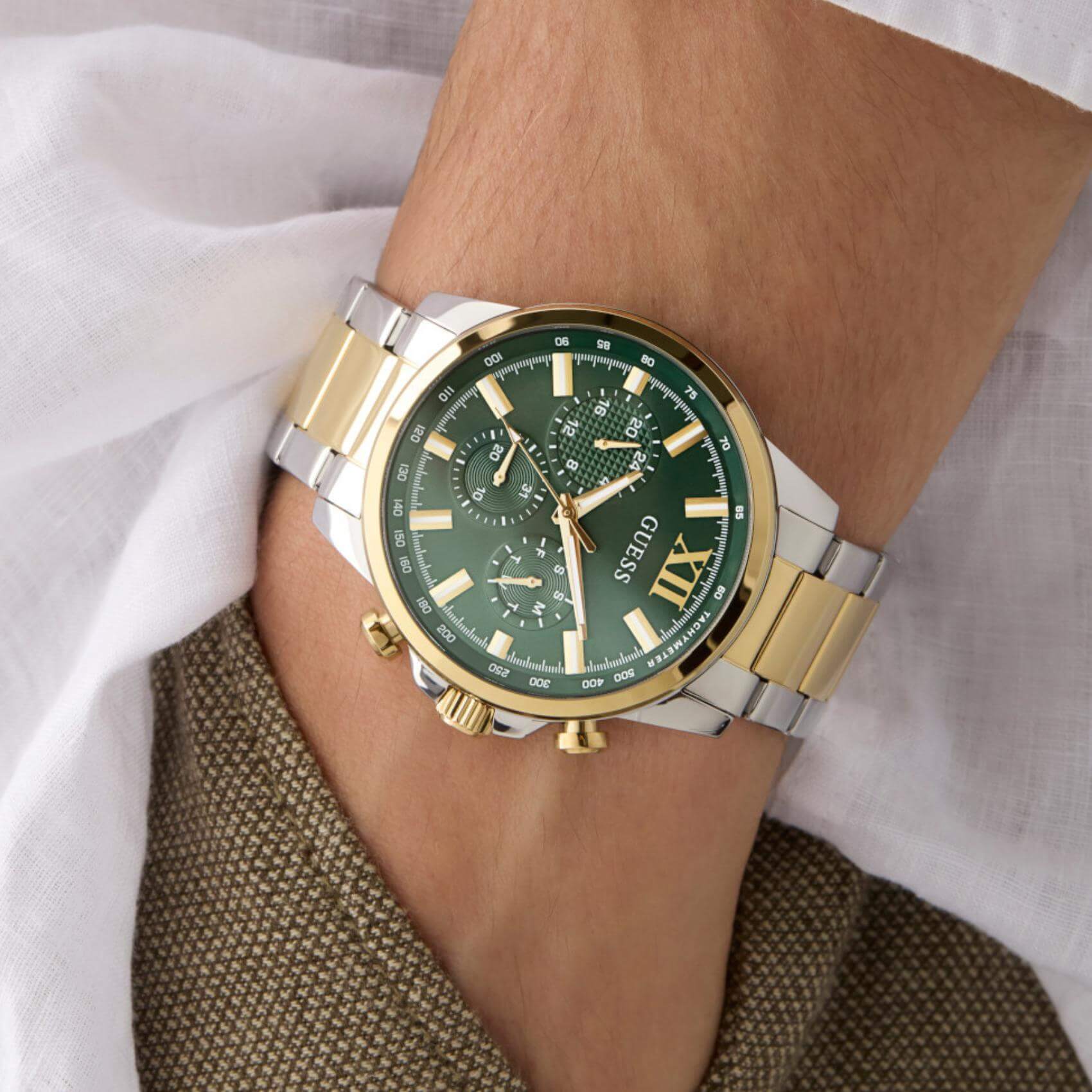 Ανδρικό ρολόι Guess Walker GW0900G5 φορεμένο με δίχρωμο ατσάλινο μπρασελέ σε ασημί και χρυσό χρώμα, πράσινο καντράν και χρυσές λεπτομέρειες.