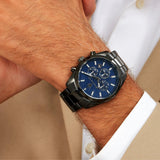 Φωτογραφία του ανδρικού ρολογιού Maserati Attrazione R8853151012 φορεμένο σε μοντέλο, αναδεικνύοντας το μαύρο μπρασελέ PVD Gun και το μπλε καντράν με ασημί δείκτες.