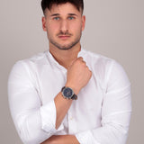 Φωτογραφία του ανδρικού ρολογιού Maserati Epoca R8871618014 φορεμένο σε μοντέλο, αναδεικνύοντας το καφέ δερμάτινο λουράκι και το μπλε καντράν με ροζ χρυσούς δείκτες.