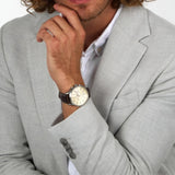 Φωτογραφία του ανδρικού ρολογιού Maserati Sorpasso R8871624010 χρονογράφου φορεμένο σε μοντέλο, αναδεικνύοντας το καφέ δερμάτινο λουράκι και το μπεζ καντράν με ροζ χρυσούς δείκτες.