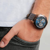 Φωτογραφία του ανδρικού ρολογιού Maserati Traguardo R8871612024 χρονογράφου φορεμένο σε μοντέλο, αναδεικνύοντας την ροζ χρυσή κάσα PVD και το καφέ δερμάτινο λουράκι με το μπλε καντράν.