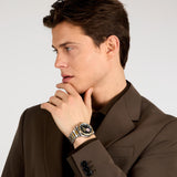 Φωτογραφία του ανδρικού ρολογιού Maserati Velocita R8823152001 φορεμένο σε μοντέλο, αναδεικνύοντας το δίχρωμο μπρασελέ σε ασημί και χρυσό και το μαύρο καντράν με εμφανή μηχανισμό