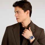 Φωτογραφία του ανδρικού ρολογιού Maserati Velocita R8823152002 φορεμένο σε μοντέλο, αναδεικνύοντας το ασημί μπρασελέ και το μπλε καντράν με ένδειξη ημερομηνίας.