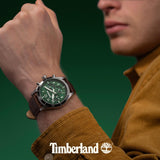 Το Timberland Ashmont TDWGF0054702 φορεμένο στον καρπό με καφέ δερμάτινο λουράκι και πράσινο καντράν.