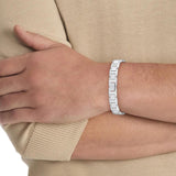 Μοντέλο φορά το ανδρικό ατσάλινο βραχιόλι Calvin Klein 35100008 με σχέδιο μπρασελέ σε ασημί χρώμα