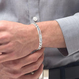 Μοντέλο φορά την ανδρική χειροπέδα Tommy Hilfiger 2790313 από ασημί ανοξείδωτο ατσάλι.