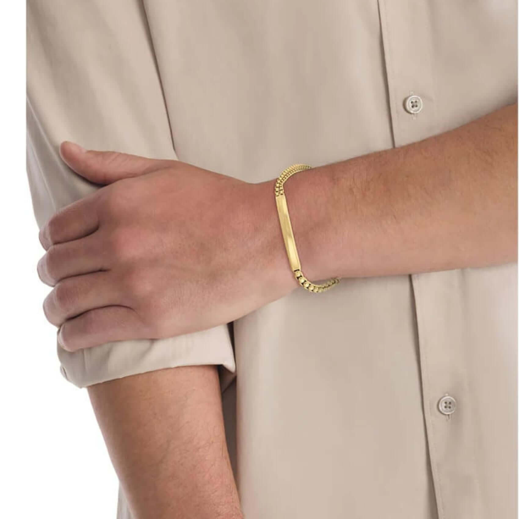 Ανδρικό βραχιόλι Calvin Klein 35100066 φορεμένο στον καρπό, σε χρυσό χρώμα με αλυσίδες και ταυτότητα.