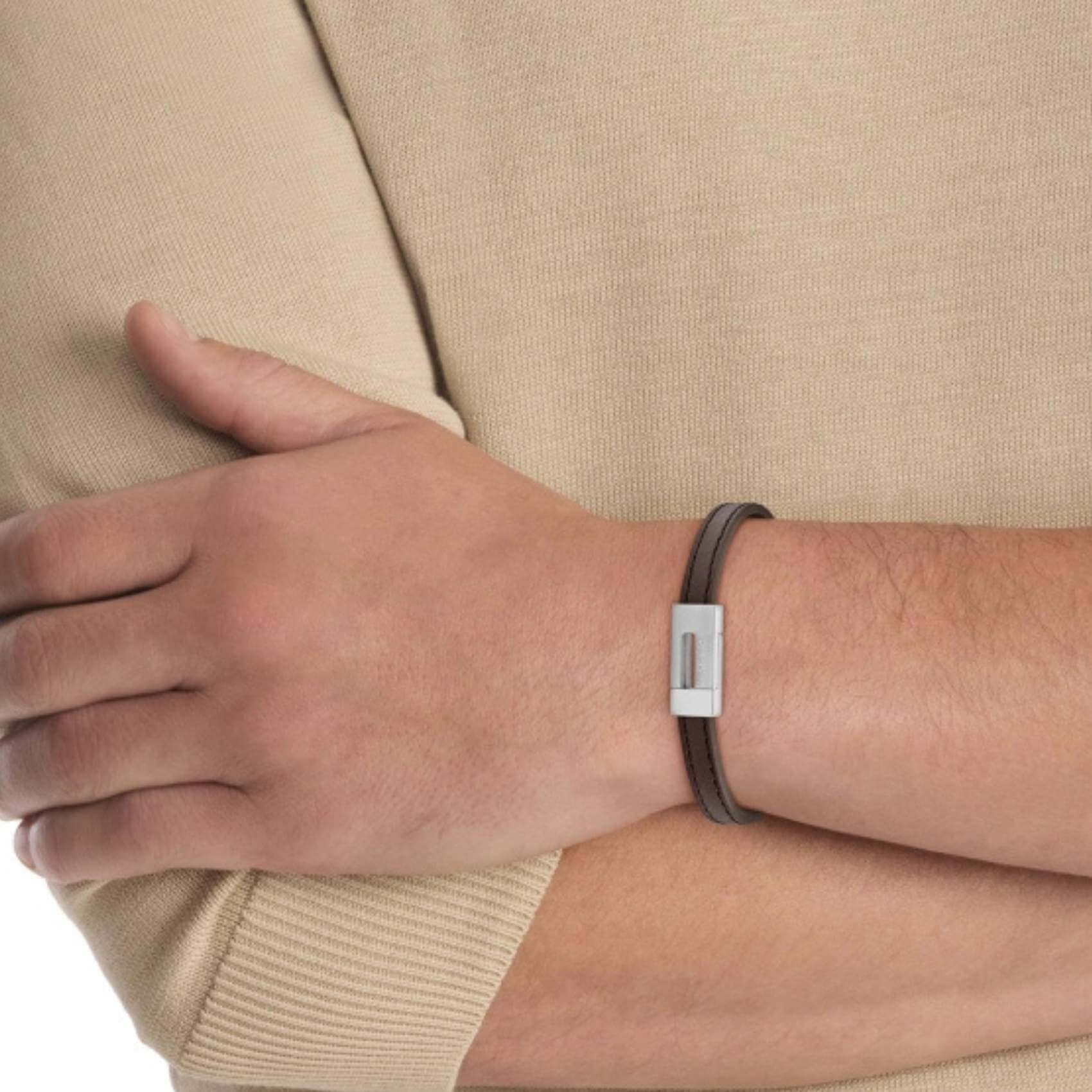 Ανδρικό Δερμάτινο Βραχιόλι σε Καφέ Χρώμα Calvin Klein 35100021 με ατσάλινο κούμπωμα, φορεμένο.