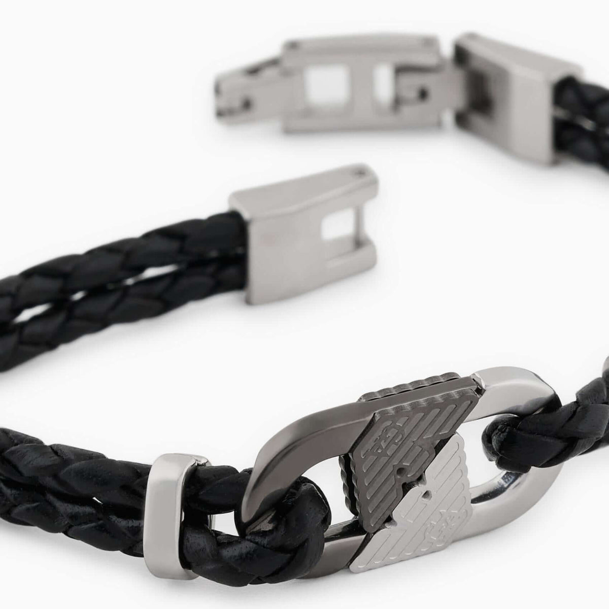 Λεπτομέρεια από το ανδρικό βραχιόλι Emporio Armani Eagle Logo EGS3171040 με μαύρο δέρμα και ατσάλινο στοιχείο σε ασημί και μαύρο χρώμα.