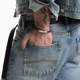 Ανδρικό βραχιόλι Emporio Armani Eagle Logo EGS3320040 φορεμένο στον καρπό, με πράσινο πλεκτό δερμάτινο λουράκι και ασημί στοιχείο ταυτότητας.