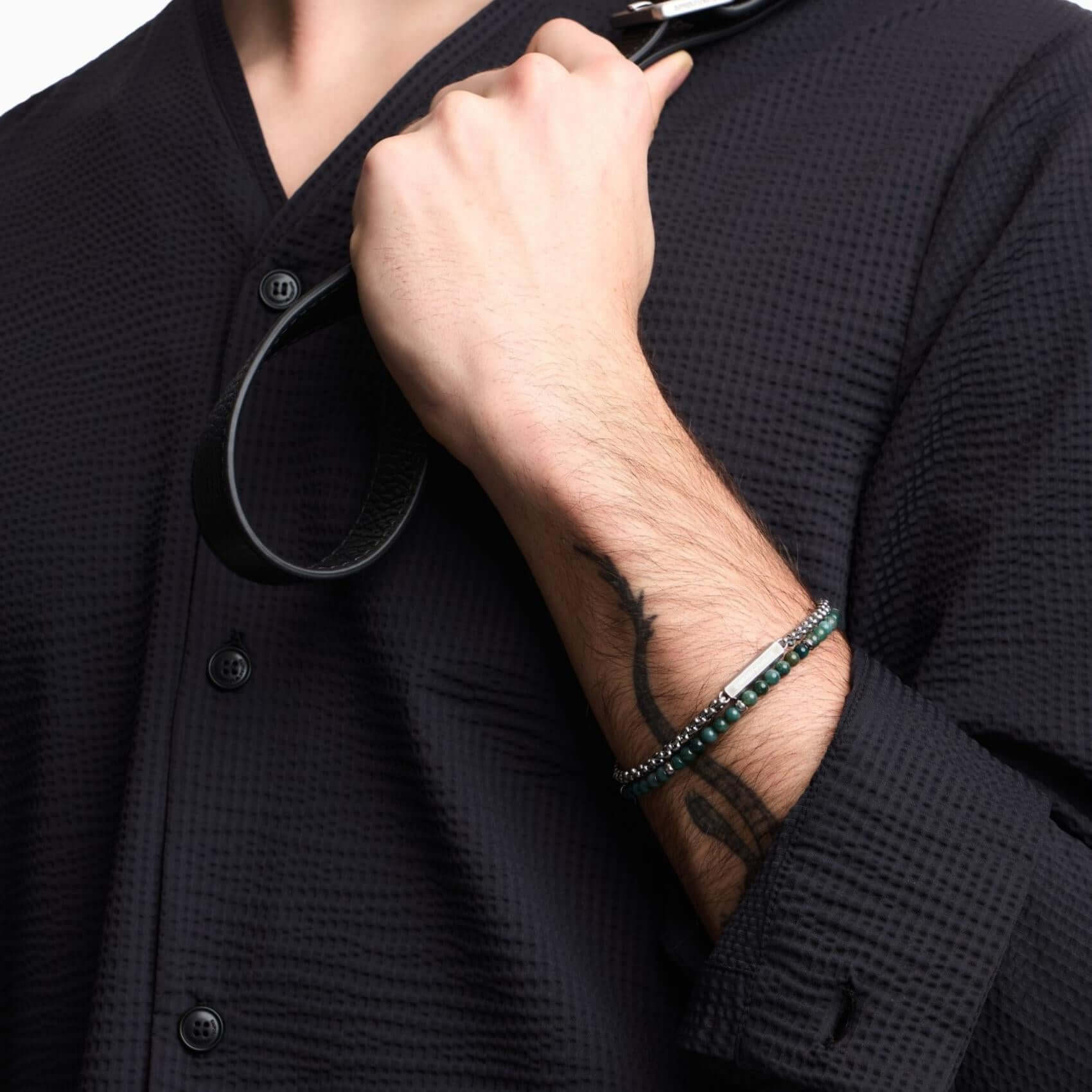 Ανδρικό βραχιόλι Emporio Armani Trend EGS3316040 φορεμένο στον καρπό, με διπλή αλυσίδα, ασημί ατσάλινο στοιχείο ταυτότητας και πράσινες χάντρες.