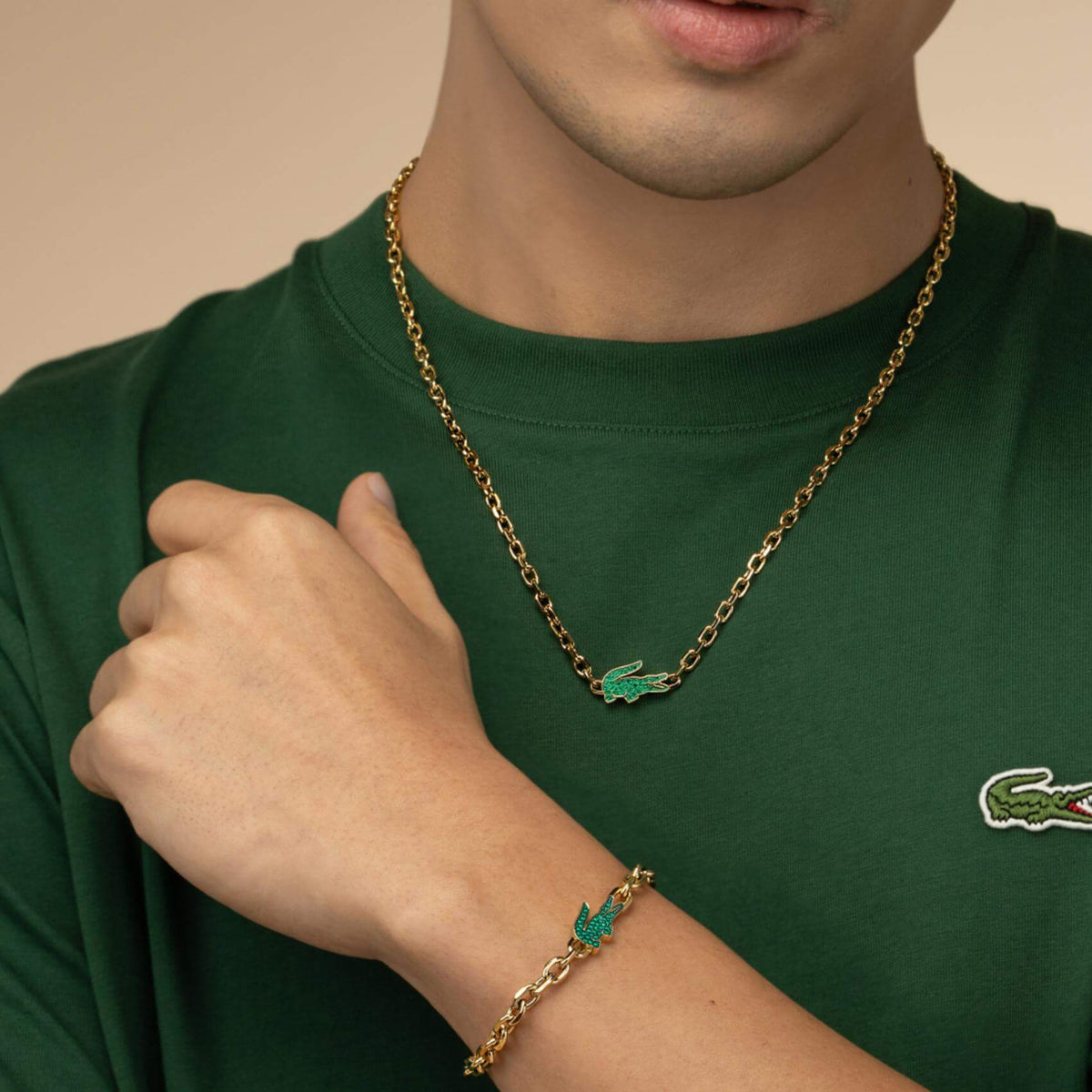 Ανδρικό βραχιόλι Lacoste 2040611 φορεμένο σε χρυσό χρώμα με κεντρικό μοτίφ κροκοδειλάκι.