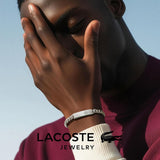 Ανδρικό βραχιόλι Lacoste 2040081 ατσάλινο σε ασημί χρώμα με ταυτότητα, φορεμένο.