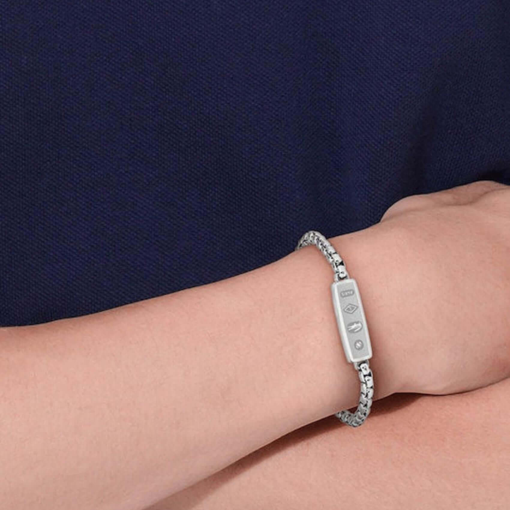 Ανδρικό βραχιόλι Lacoste 2040538 ατσάλινο σε ασημί χρώμα με ταυτότητα διασκοσμημένη με τα 4 χαρακτηριστικά μοτίβα της συλλογής, φορεμένο