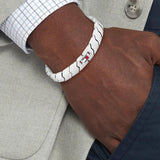 Ανδρικό ατσάλινο βραχιόλι Tommy Hilfiger 2790619 χειροπέδα σε ασημένιο χρώμα και σχέδιο μπρασελέ, φορεμένο.