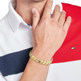 Ανδρικό ατσάλινο βραχιόλι Tommy Hilfiger 2790620 χειροπέδα σε χρυσό χρώμα και σχέδιο μπρασελέ, φορεμένο.