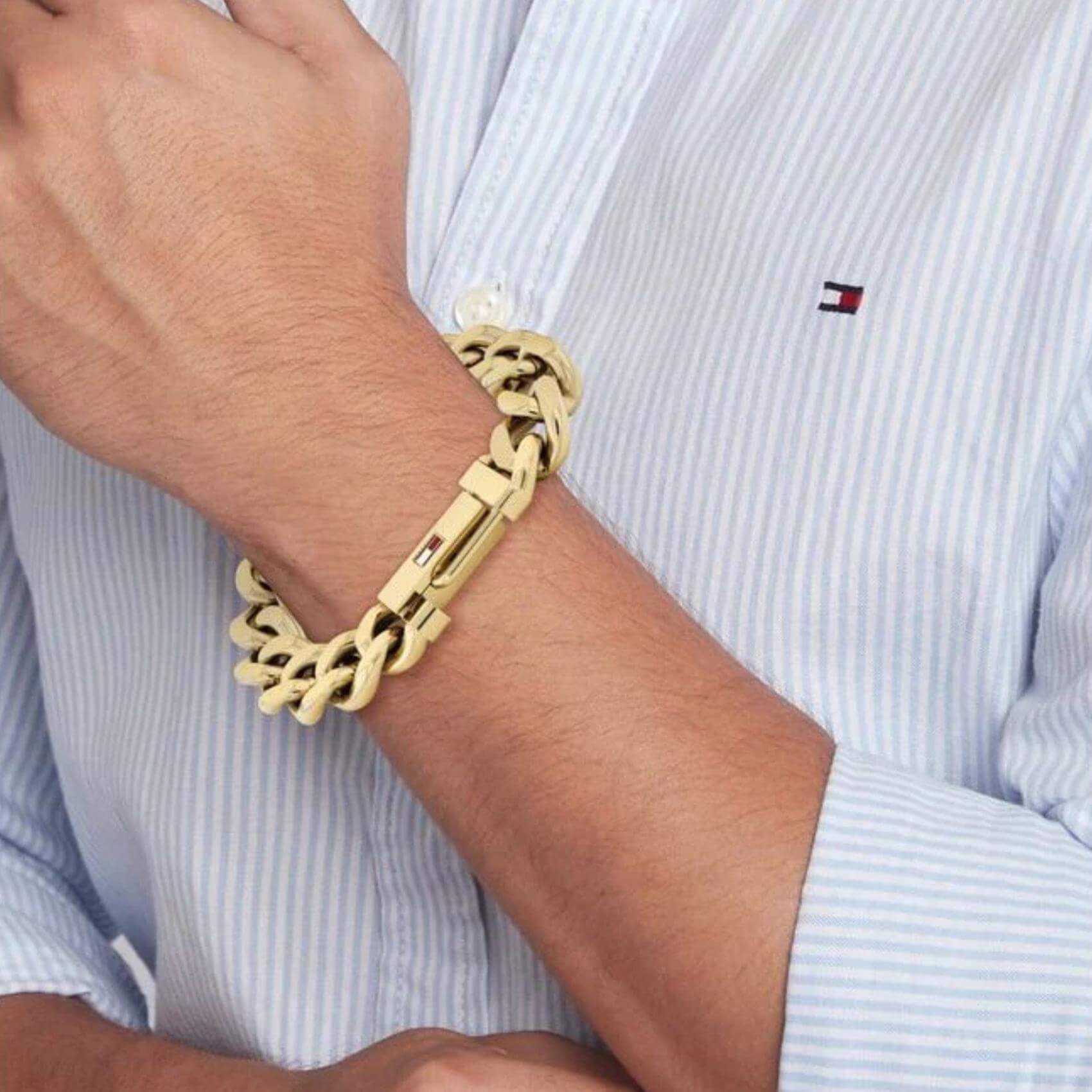 Ανδρικό ατσάλινο βραχιόλι Tommy Hilfiger 2790638 χειροπέδα σε χρυσό χρώμα και σχέδιο αλυσίδας με διαγώνια πλέξη, φορεμένο.